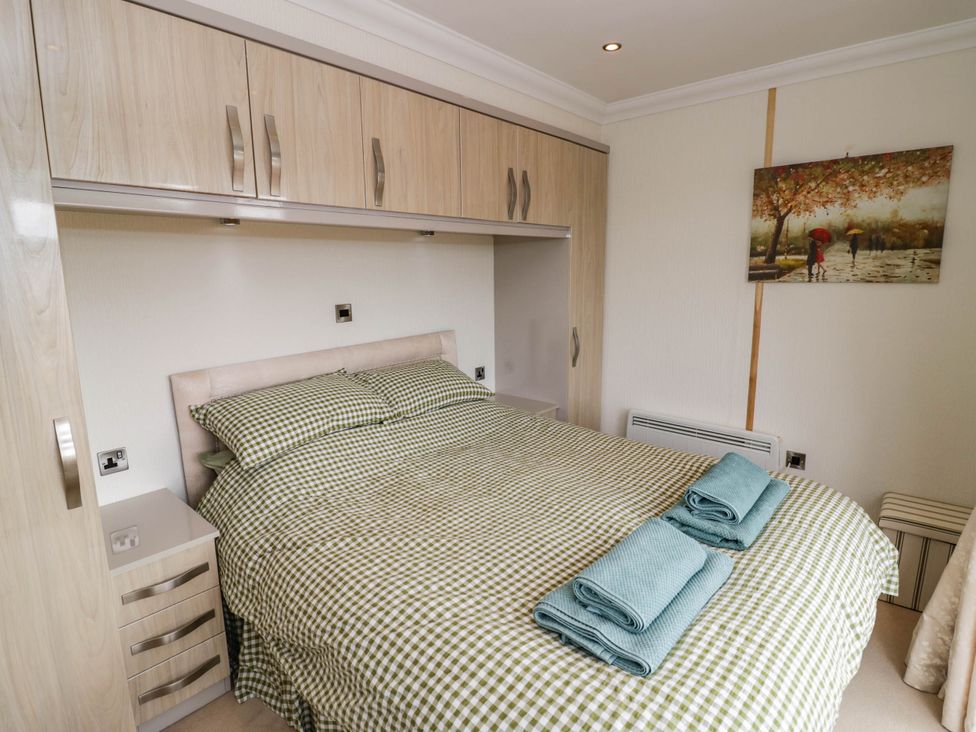 A bedroom with a bed and bedside cabinet at Cabin In The Woods Silverstone