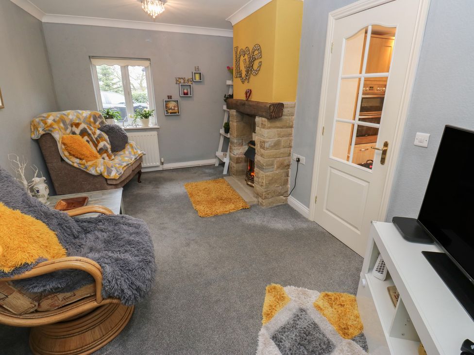 A living room with a fireplace and sofa at The Annex at Ryefield Lodge