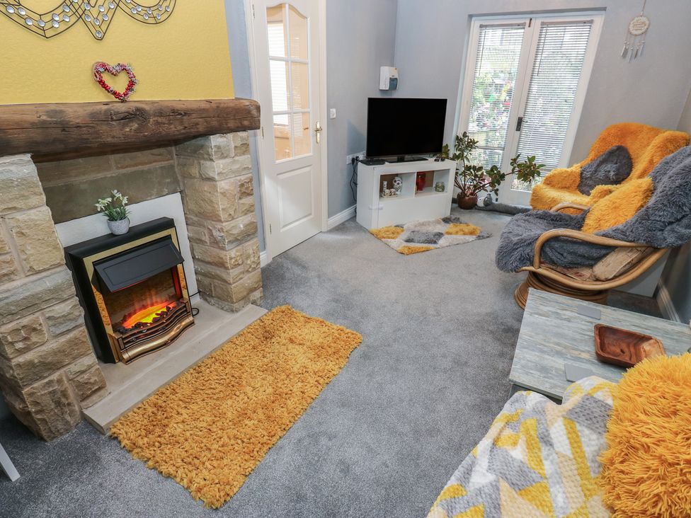 A living room with a fireplace and television at The Annex at Ryefield Lodge