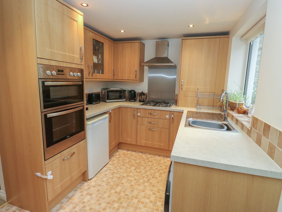 A kitchen with wooden cabinets and appliances at The Annex at Ryefield Lodge