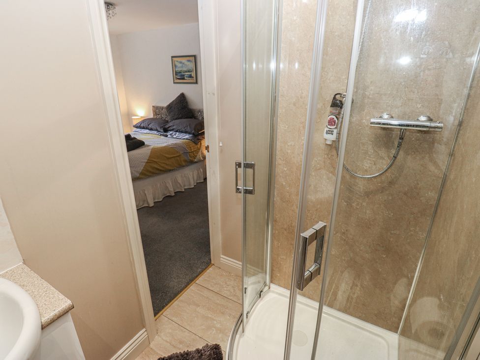 A bathroom with a shower and door leading to a bedroom at The Annex at Ryefield Lodge