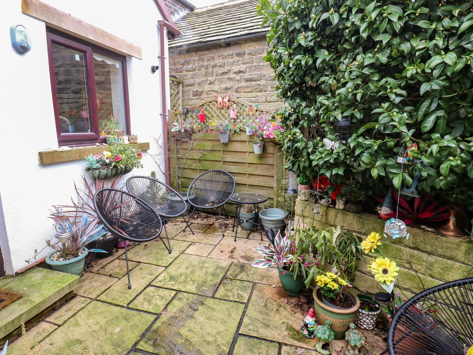 A garden with chairs and flower pots at The Annex at Ryefield Lodge 