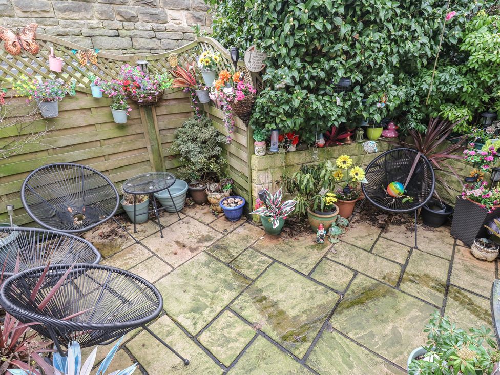 A garden area with chairs, a table, and various flower pots at The Annex at Ryefield Lodge
