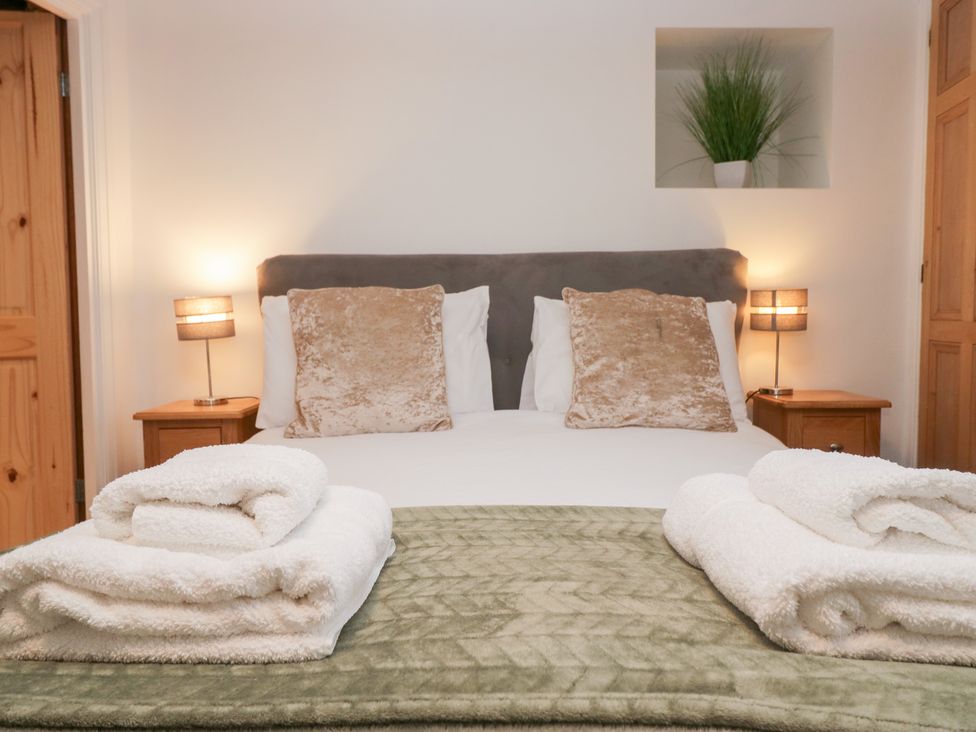 A bedroom with a bed and towels on display at No.2 The Flags, Grange-over-Sands