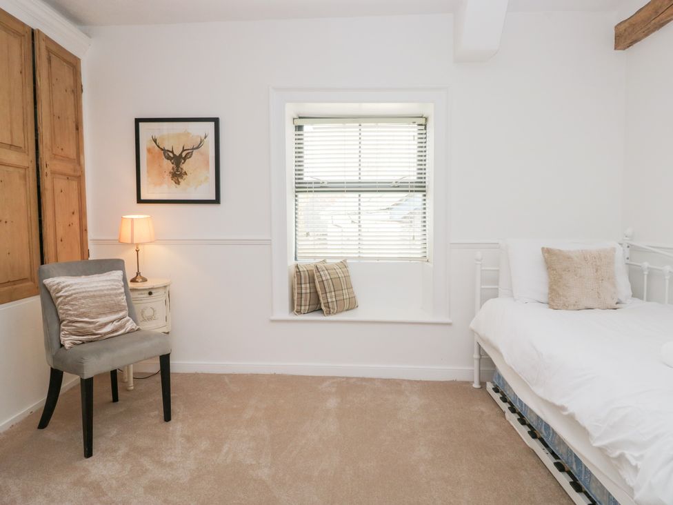 A bedroom with a bed and a chair at No.2 The Flags in Grange-over-Sands