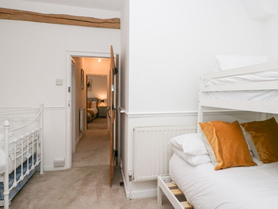 A bedroom with a bunk bed and single bed at No.2 The Flags, Grange-over-Sands