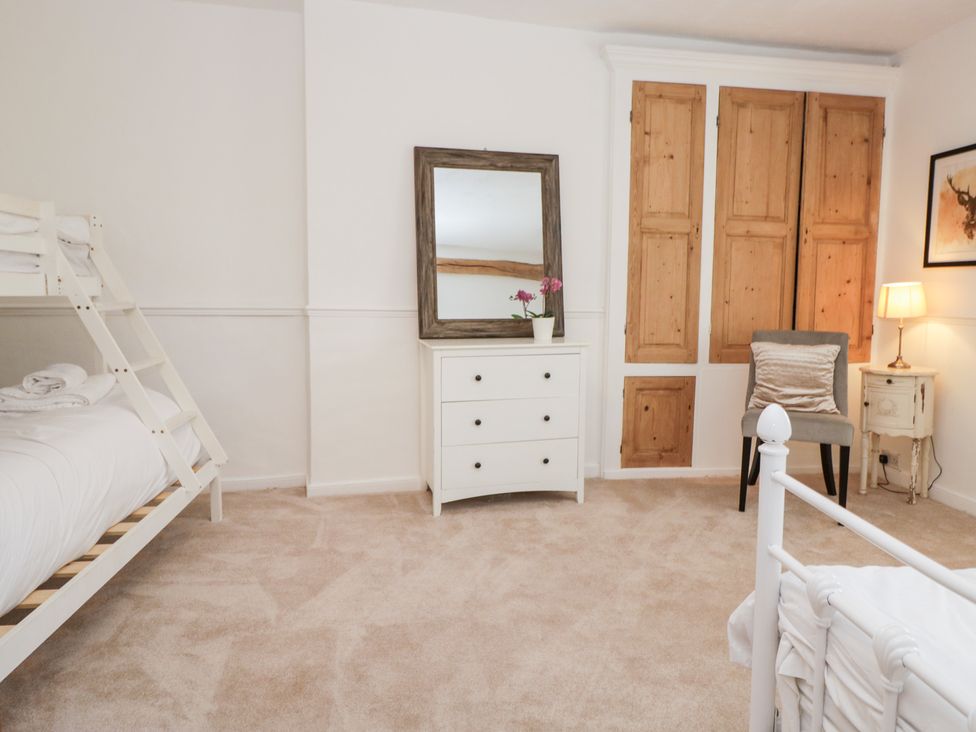 A bedroom with a bunk bed and dresser at No.2 The Flags, Grange-over-Sands