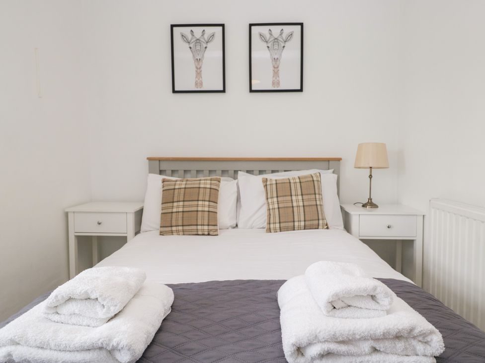 A bedroom with a bed and framed art at No.2 The Flags, Grange-over-Sands