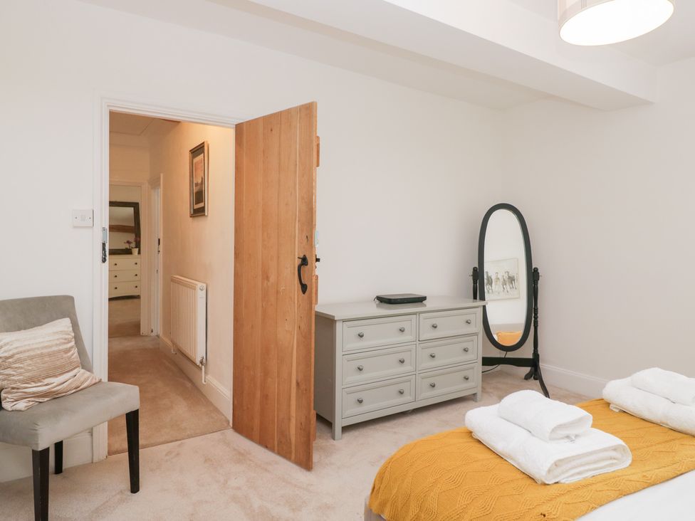 A bedroom with a bed and dresser at No.2 The Flags, Grange-over-Sands