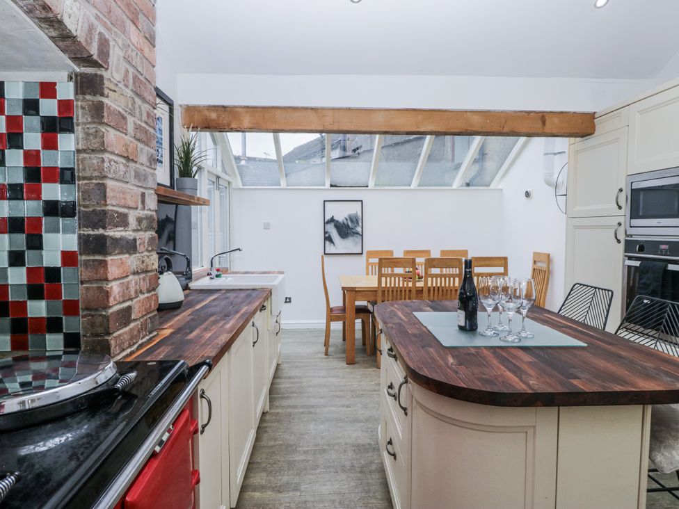 A kitchen with an island and dining table at No.2 The Flags in Cartmel