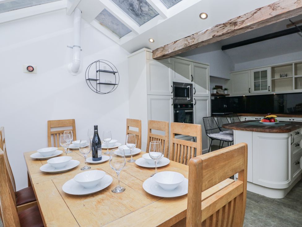 A dining room with a table set for dinner at No.2 The Flags in Cartmel