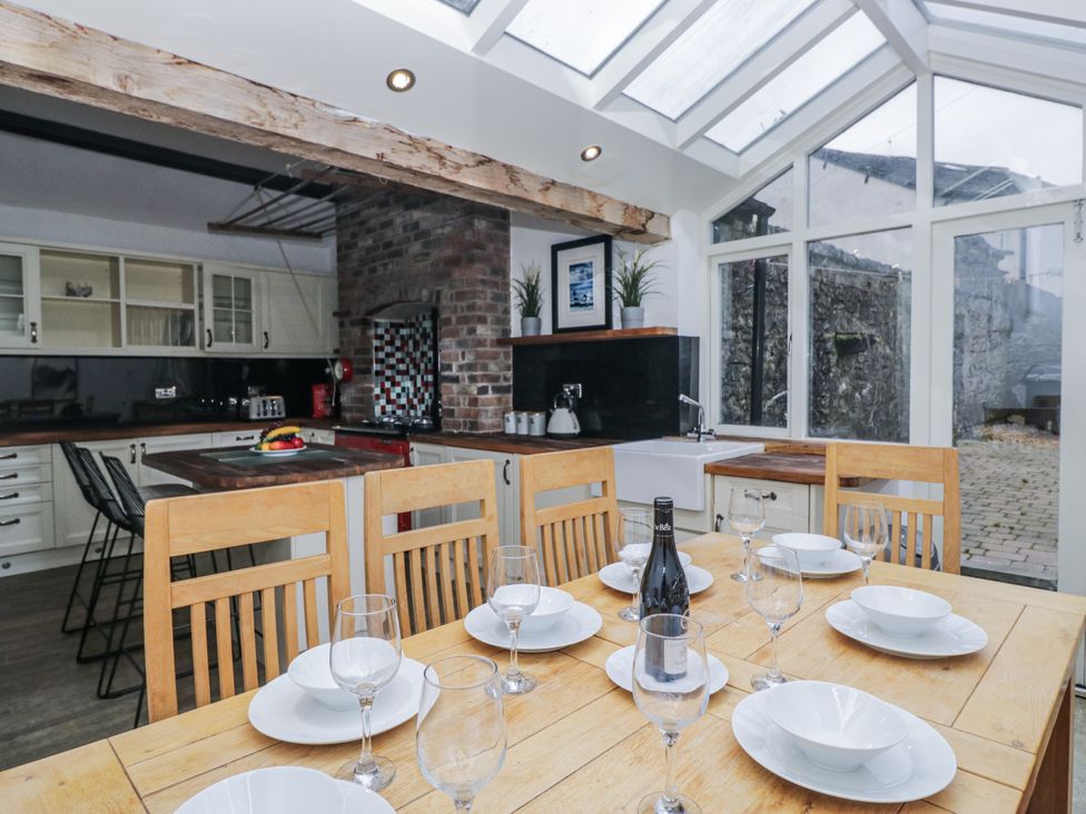 A dining room with a wooden table set for a meal at No.2 The Flags in Cartmel