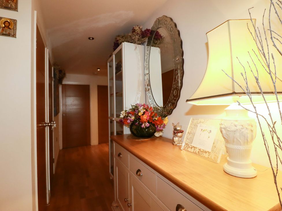 A hallway with a mirror and lamp at 2 Morweth View Torpoint