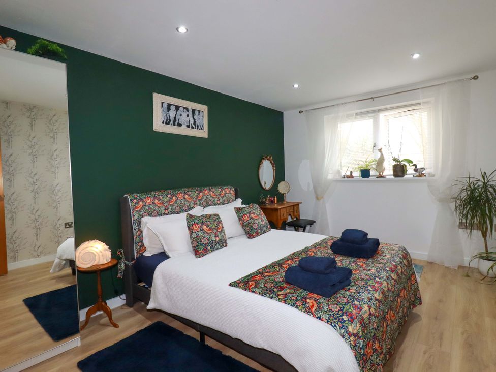 A bedroom with a bed and plants at 2 Morweth View in Torpoint