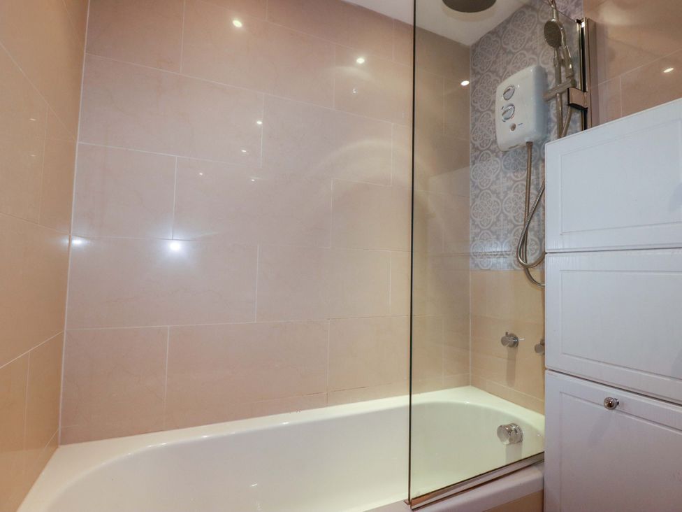 A bathroom with a bathtub and shower at 2 Morweth View Torpoint