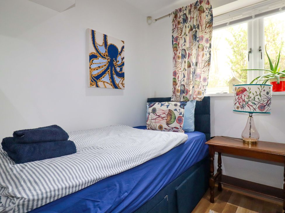 A bedroom with a bed and lamp at 2 Morweth View Torpoint