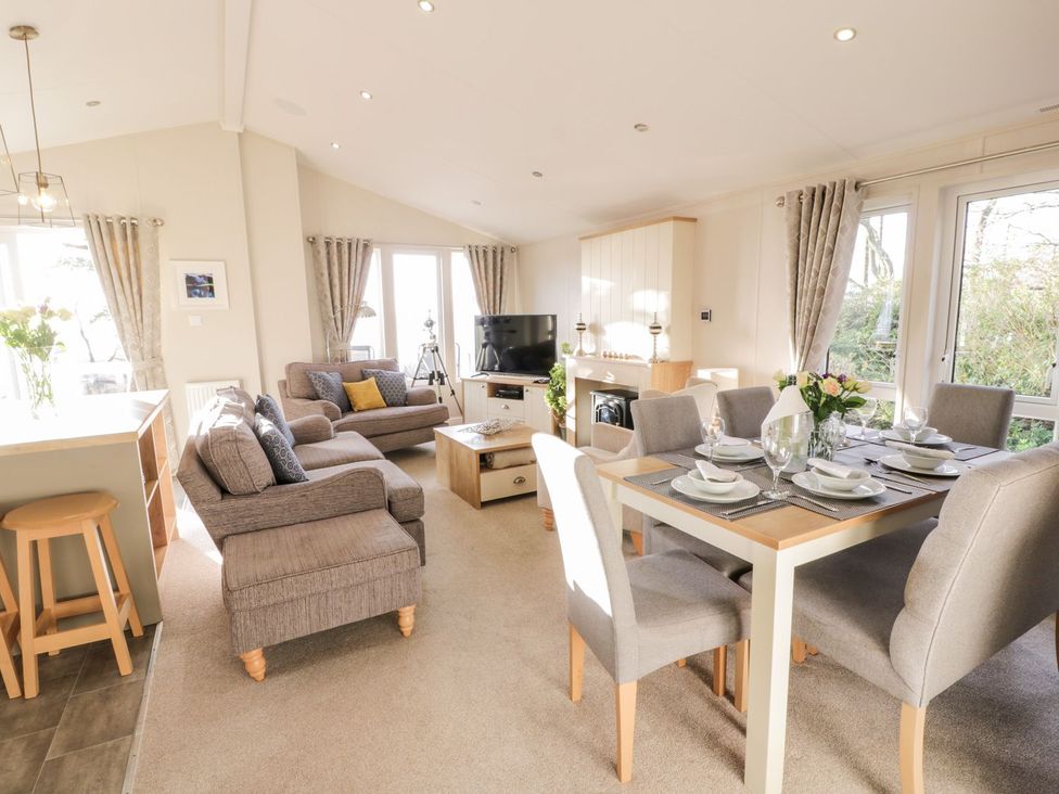 A living room with a sofa and dining table at Serenity Lodge in Wemyss Bay