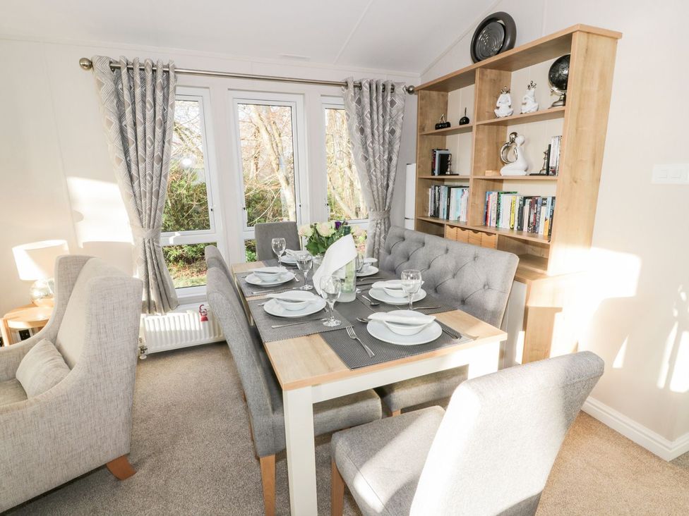 A dining room with a table set for dinner at Serenity Lodge in Wemyss Bay