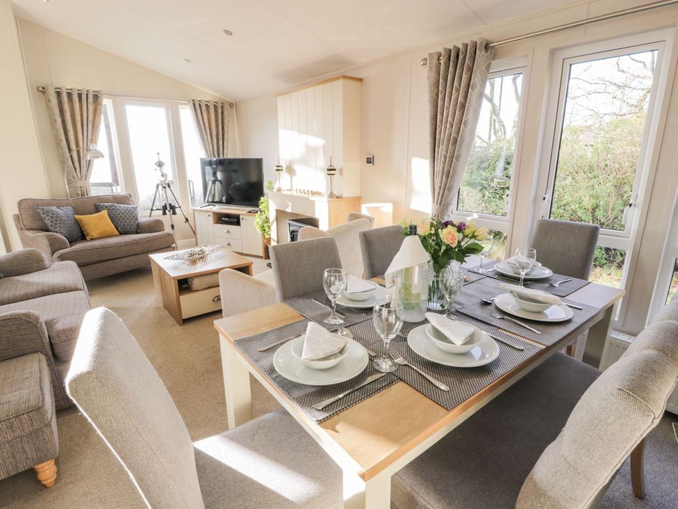 A dining room with a table set for meals at Serenity Lodge in Wemyss Bay