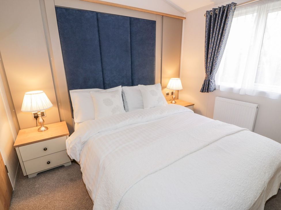 A bedroom with a bed and bedside lamps at Serenity Lodge in Wemyss Bay