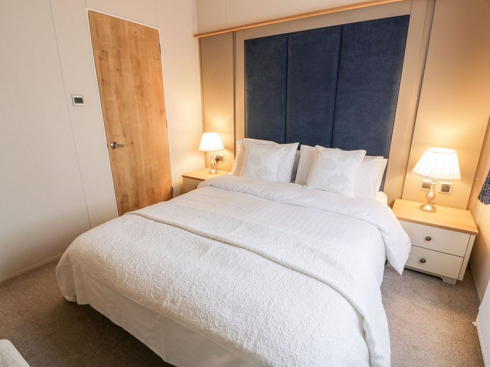 A bedroom with a bed and bedside table at Serenity Lodge in Wemyss Bay