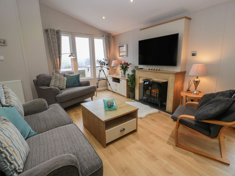 A living room with a sofa and fireplace at Serenity Lodge in Wemyss Bay