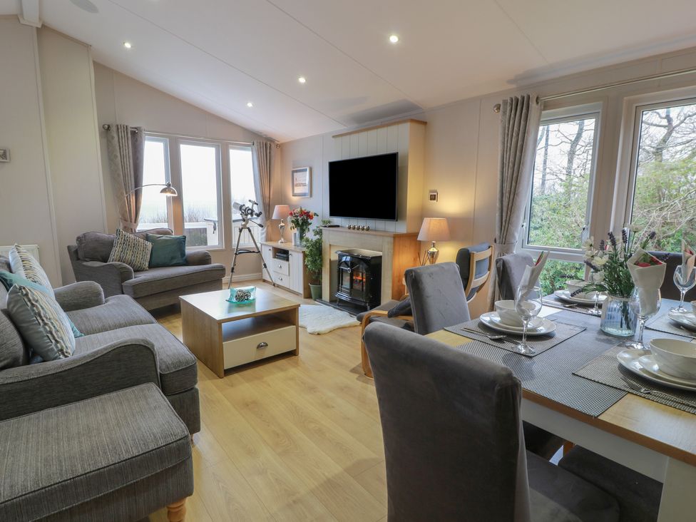 A living room with a sofa and dining table at Serenity Lodge in Wemyss Bay