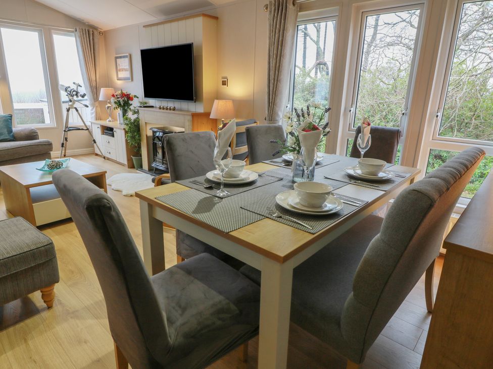 A dining table with tableware in a dining room at Serenity Lodge Wemyss Bay