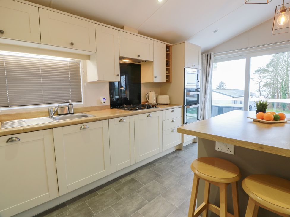 A kitchen with cabinets and appliances at Serenity Lodge in Wemyss Bay