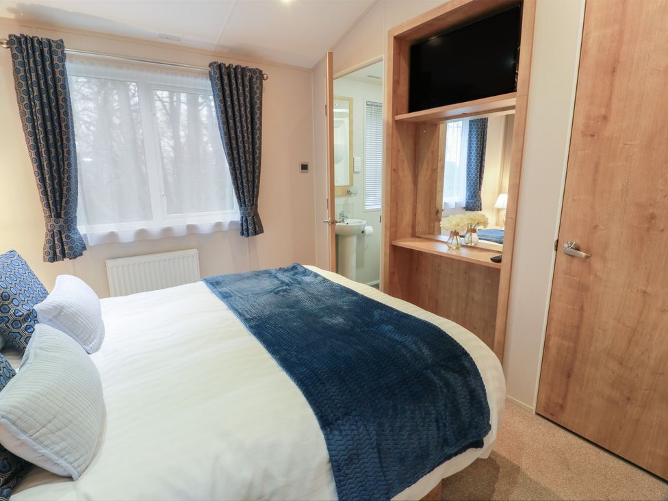 A bedroom with a bed and a TV at Serenity Lodge in Wemyss Bay