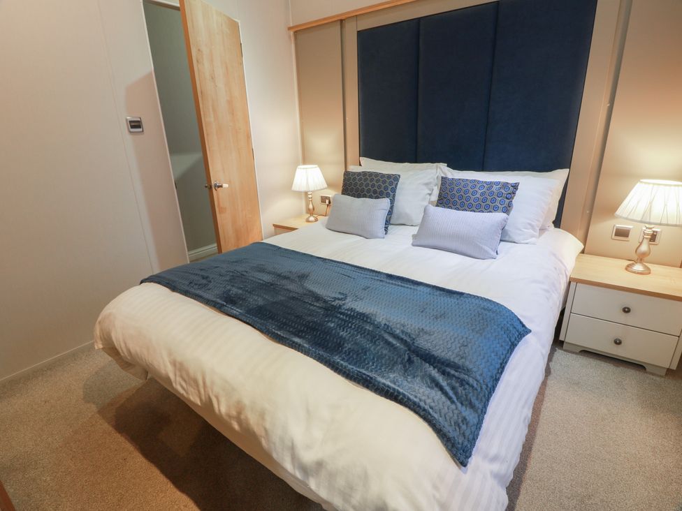 A bedroom with a bed and bedside lamps at Serenity Lodge in Wemyss Bay