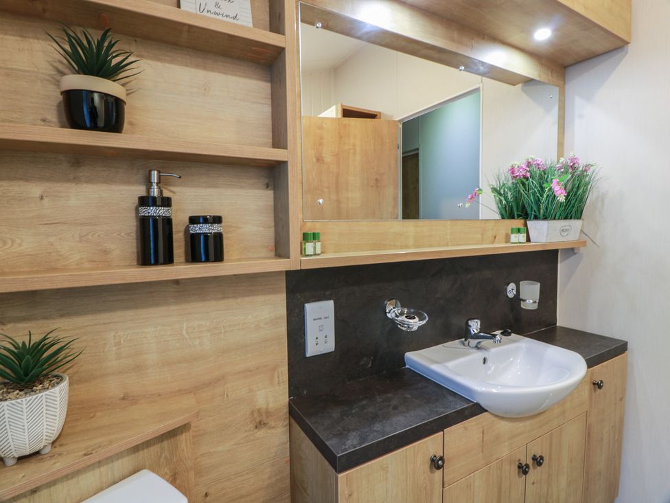 A bathroom with a sink and mirror at Serenity Lodge in Wemyss Bay