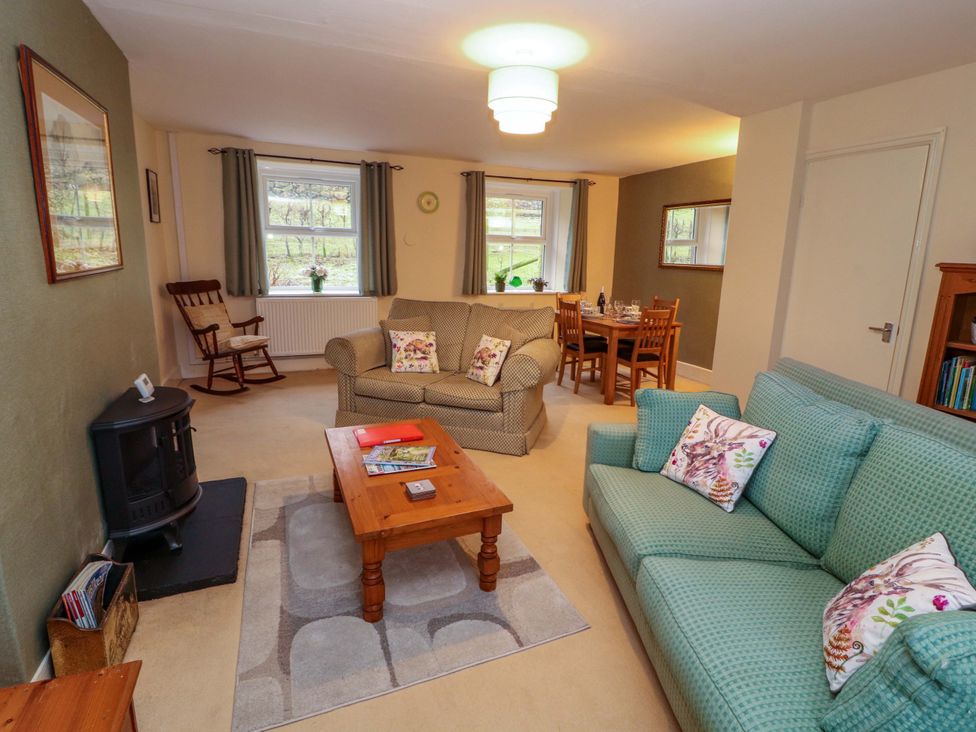 A living room with seating and a dining table at Easthwaite Cottage in Holmrook near Easthwaite Farm