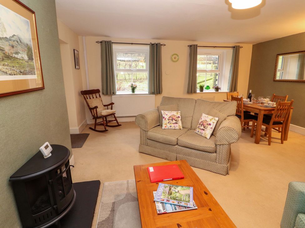 A living room with a sofa and dining table at Easthwaite Cottage Holmrook near Easthwaite Farm