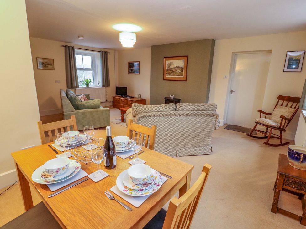 A dining area with a table set for dinner at Easthwaite Cottage in Holmrook near Easthwaite Farm
