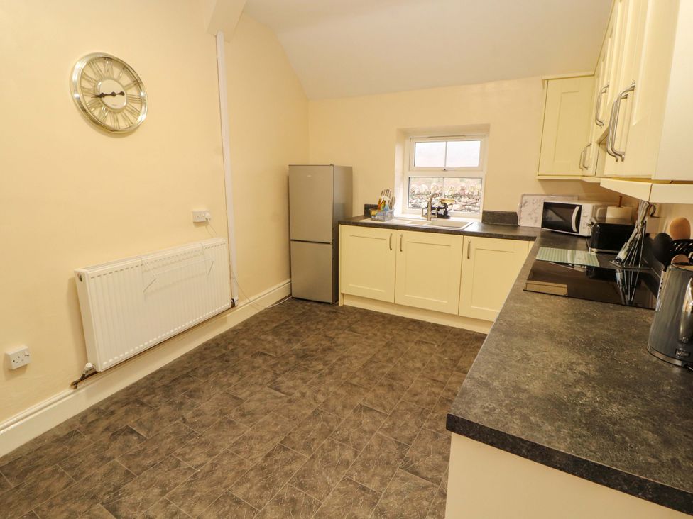 A kitchen with a refrigerator and sink at Easthwaite Cottage Holmrook near Easthwaite Farm