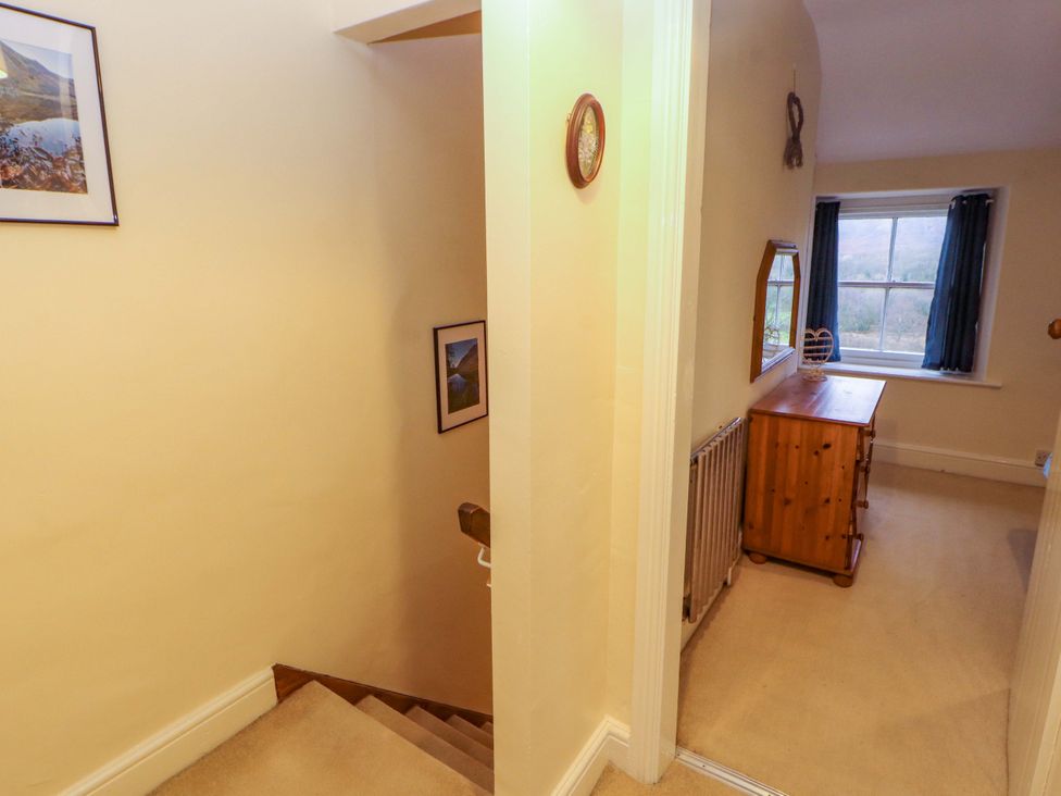 A hallway with a staircase and a dresser at Easthwaite Cottage Holmrook near Easthwaite Farm