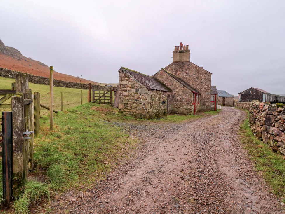 A stone cottage and shed near a dirt road at Easthwaite Cottage Holmrook near Easthwaite Farm