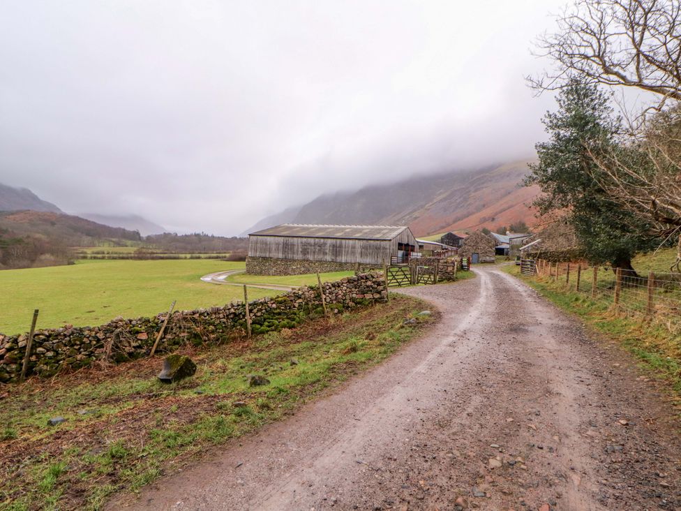 A barn and stone wall along a gravel road at Easthwaite Cottage Holmrook near Easthwaite Farm