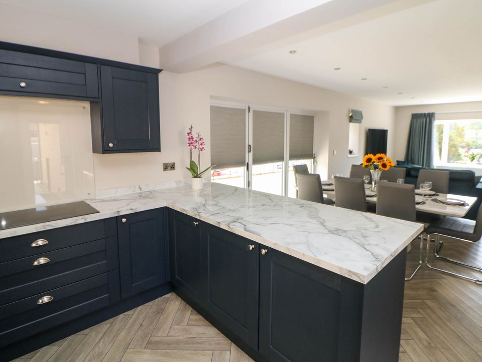 A kitchen with dark cabinets and marble countertop at The Bungalow in Matlock