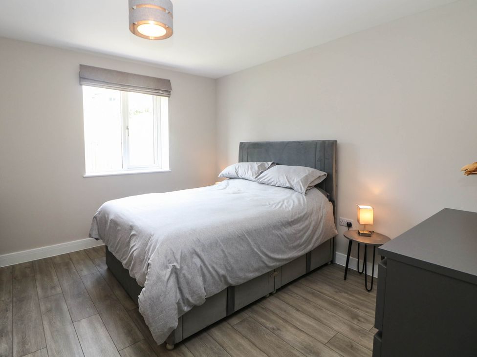A bedroom with a bed and window at The Bungalow in Matlock