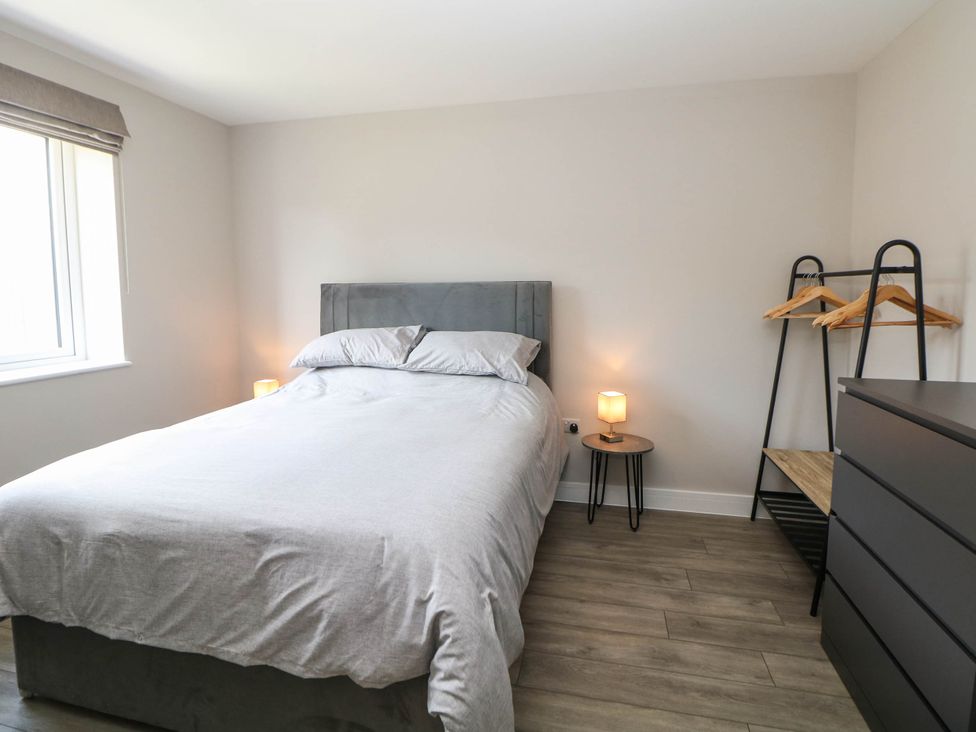 A bedroom with a bed, bedside table, and dresser at The Bungalow in Matlock
