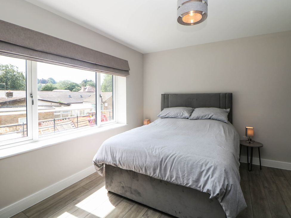 A bedroom with a bed and windows at The Bungalow in Matlock
