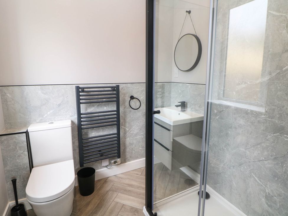 A bathroom with a shower, sink, and toilet at The Bungalow in Matlock