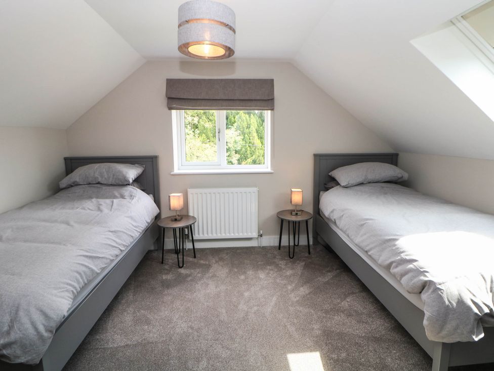 A bedroom with two single beds and a window at The Bungalow in Matlock