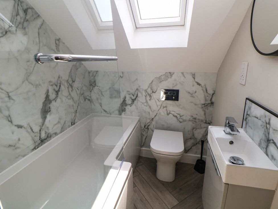 A bathroom with bathtub, toilet, and sink at The Bungalow in Matlock