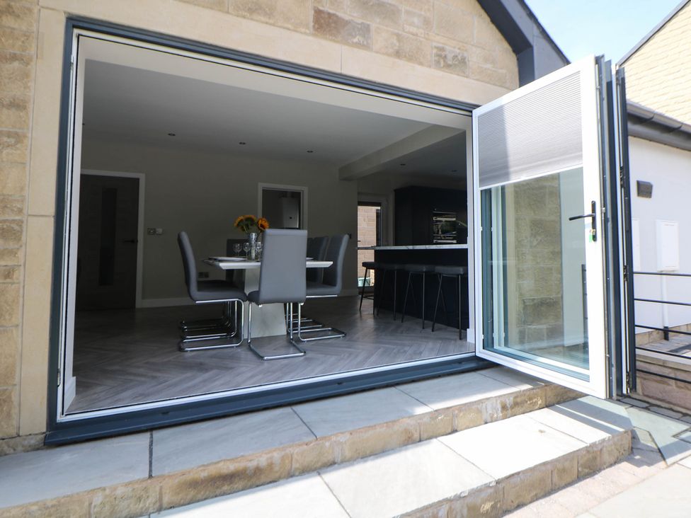 A dining room with a sliding door leading to an outdoor area at The Bungalow in Matlock
