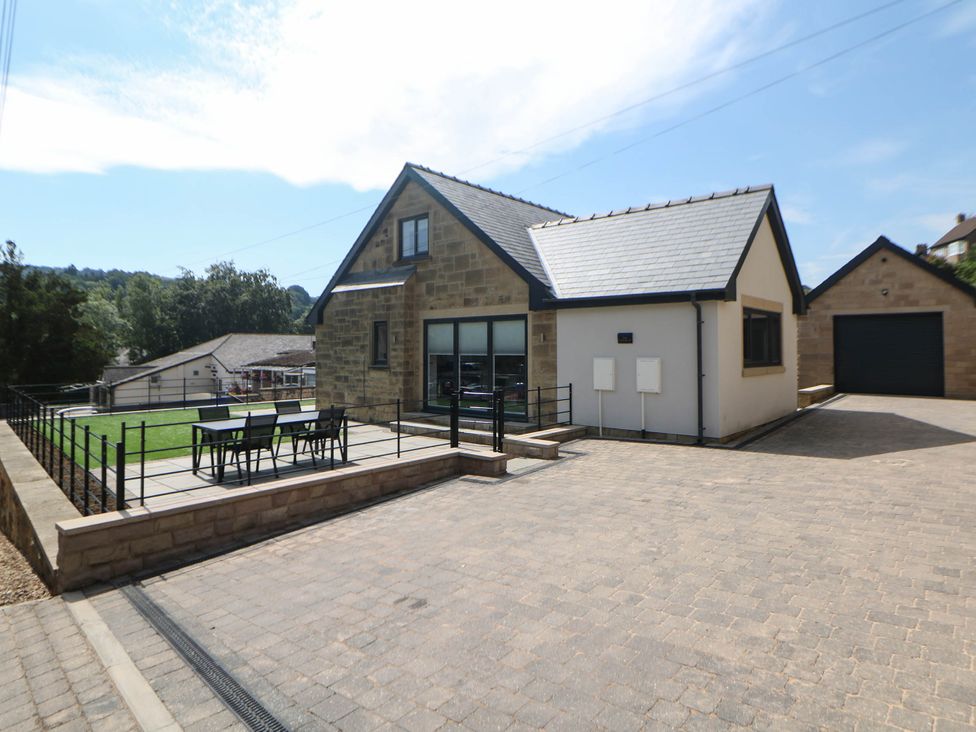 A house with a parking area and outdoor seating at The Bungalow in Matlock