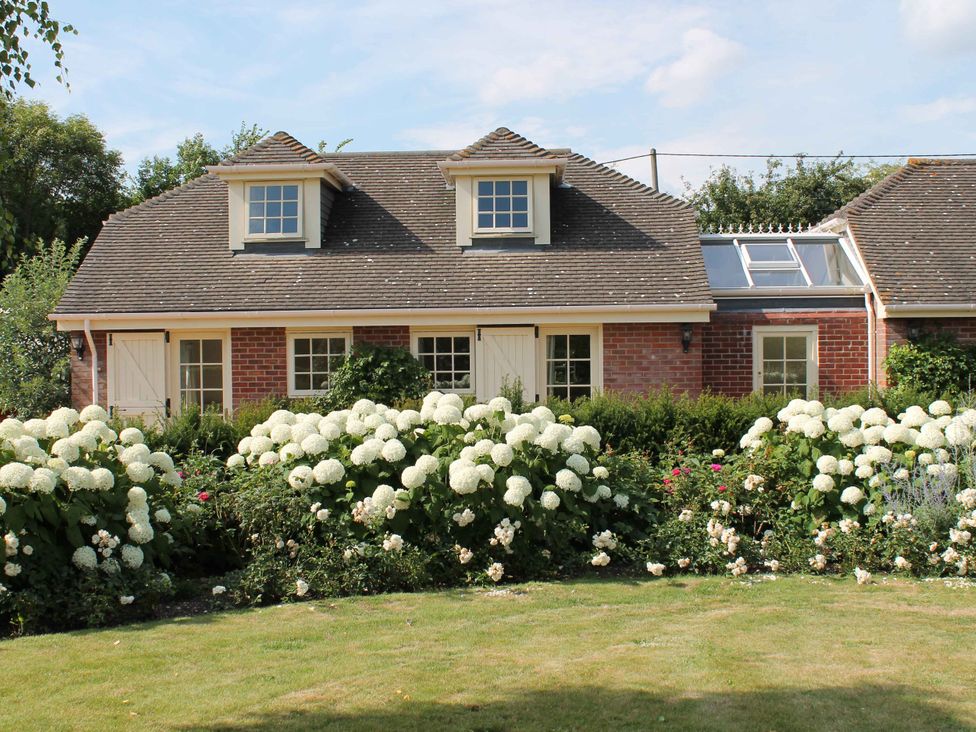 A house with flowers in the garden at New Barn in Broad Chalke