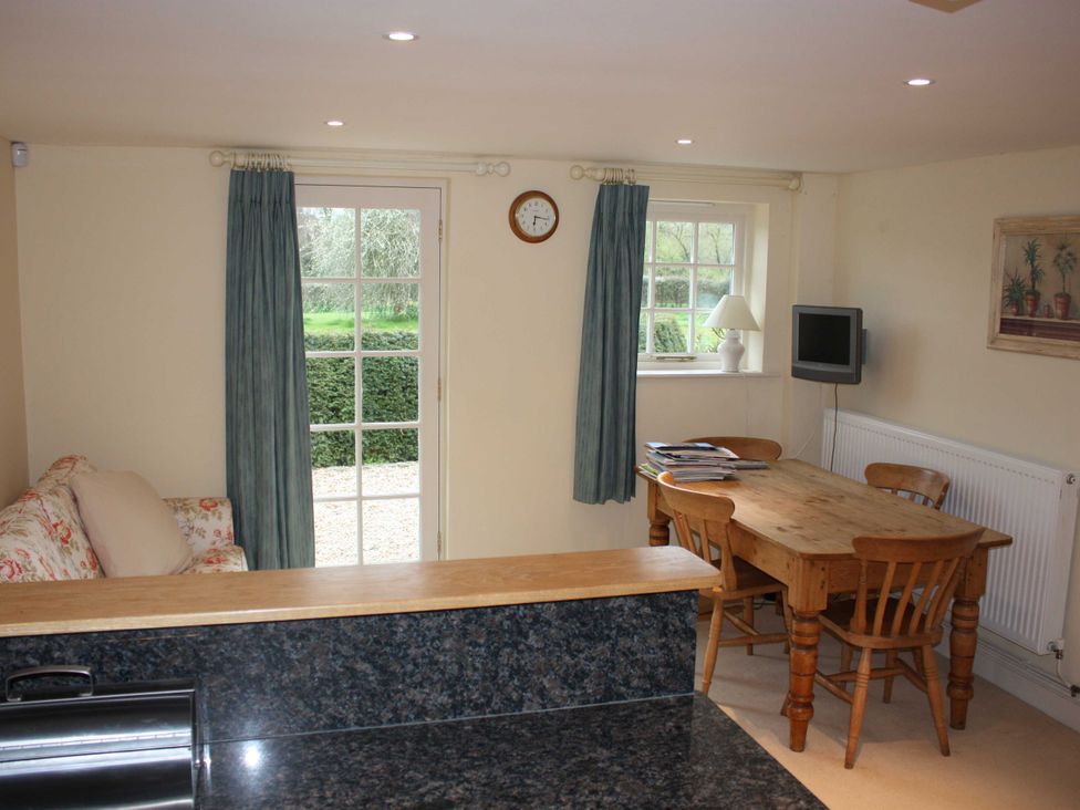 A kitchen with a dining table and chairs at New Barn in Broad Chalke